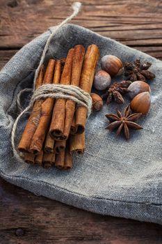 Bunch of cinnamon sticks and star anise on sackcloth in vintage style