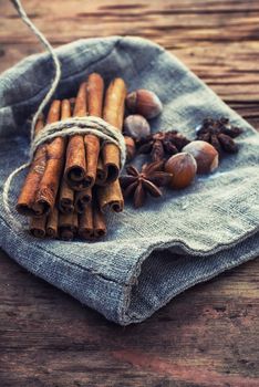 Bunch of cinnamon sticks and star anise on sackcloth in vintage style