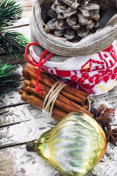 Christmas bag with pine cones on wooden snowy background