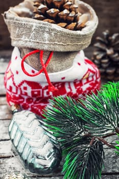 Christmas bag with pine cones on wooden snowy background