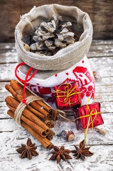 Christmas bag with pine cones on wooden snowy background