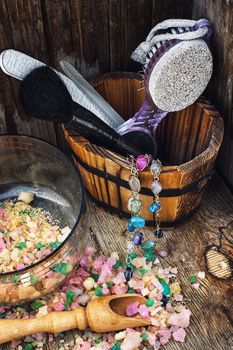 Scrub,brush,nail file in wooden tub on the background scattered with sea salt for Spa treatments.