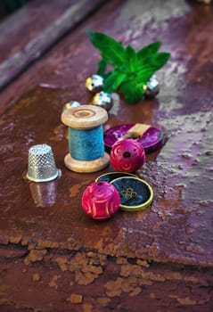 set of threads and buttons on old wooden background