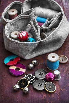 set of threads and buttons on old wooden background
