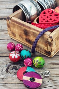 accessories of beads and threads for needlework on wooden plank