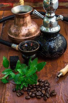 Hookah with fruit flavour on wooden table in vintage style