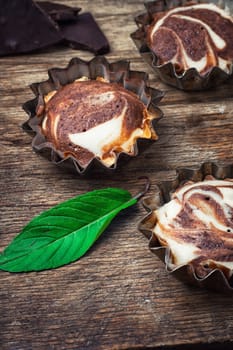 Baked chocolate cupcakes in tins on wooden table