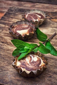 Baked chocolate cupcakes in tins on wooden table