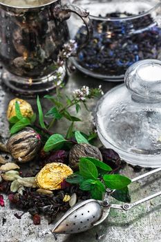 Various dry tea brew on iron background with tea paraphernalia.
