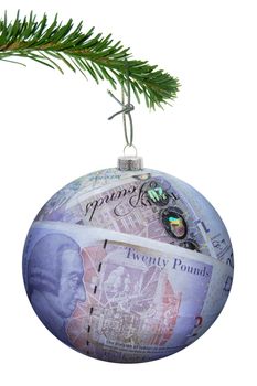 Christmas bauble made of pound banknotes hanging from a tree 