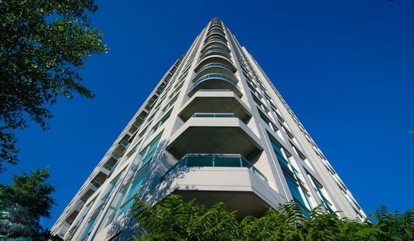 Looking up.  View on the corner of a new Condominium building project.  Modern living, urban buildings.