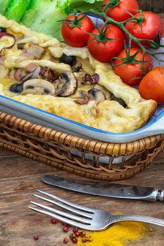 Pizza is of irregular shape elongated in length with fresh vegetables.Tinted