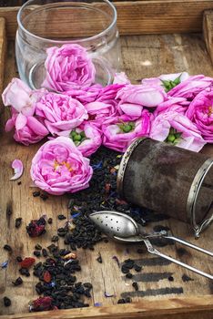 buds of the tea roses in wooden box with welding in rustic style