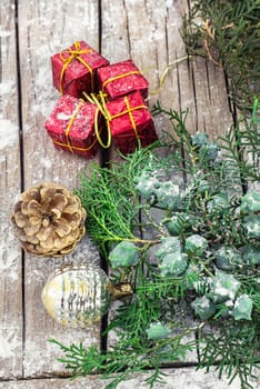 Christmas decorations with red boxes on wooden background decorated with fir branch