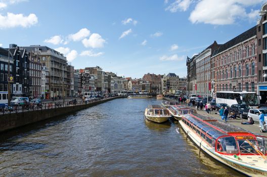 Amsterdam, Netherlands - May 7, 2015: Passenger boats on canal tour in the city of Amsterdam on May 7, 2015. Amsterdam is the capital and most populous city of the Netherlands.