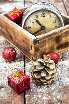 outdated watch in wooden box on the background of Christmas decorations and pine cones.