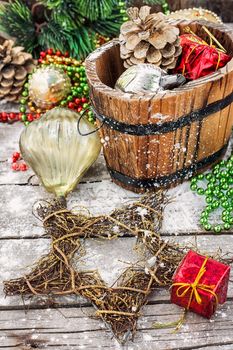 Decorative wooden tub filled with Christmas ornaments and pine cones