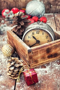 outdated watch in wooden box on the background of Christmas decorations and pine cones.