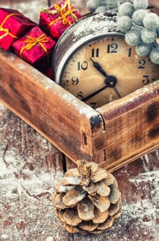 outdated watch in wooden box on the background of Christmas decorations and pine cones.