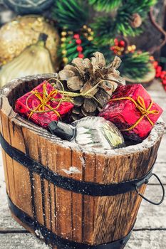 Decorative wooden tub filled with Christmas ornaments and pine cones