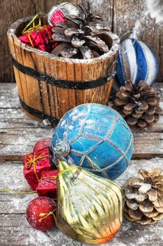 Decorative wooden tub filled with Christmas ornaments and pine cones