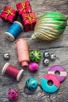 spool of thread and Christmas decorations on wooden background