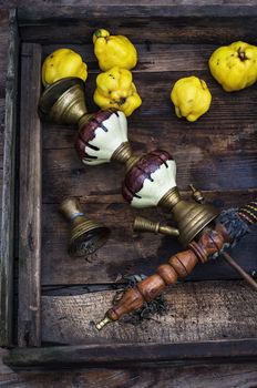 Stylish hookah disassembled in wooden box with fragrant autumn fruit quince.