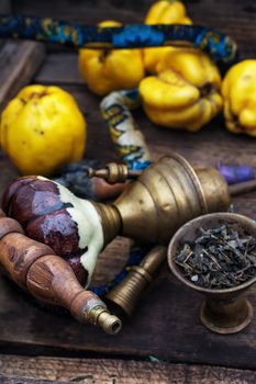 Stylish hookah disassembled in wooden box with fragrant autumn fruit quince.