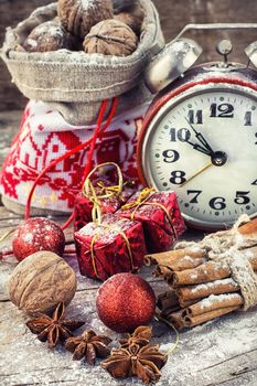 An alarm clock and bag of nuts on the background of Christmas decorations