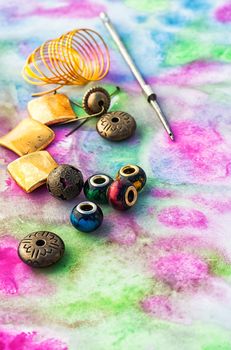Beads and tools for needlework on bright background