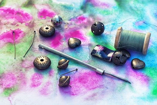 Beads and tools for needlework on bright background