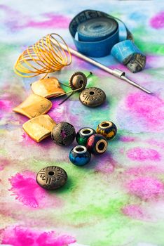 Beads and tools for needlework on bright background