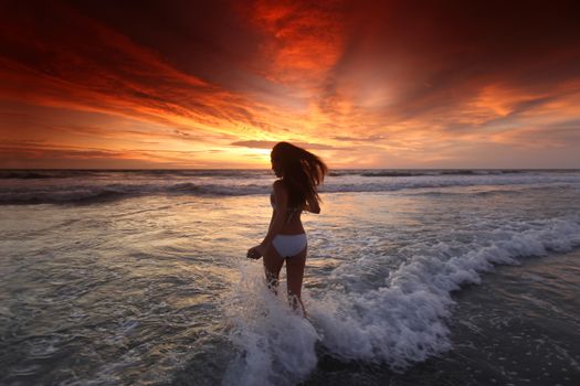 Happy woman running on the beach at sunset, Bali, Seminyak, Double six beach