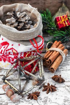 Christmas bag with pine cones on wooden snowy background