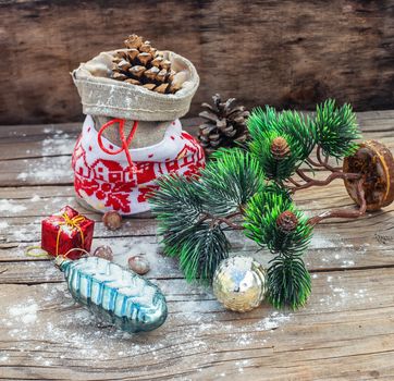 Christmas bag with pine cones on wooden snowy background