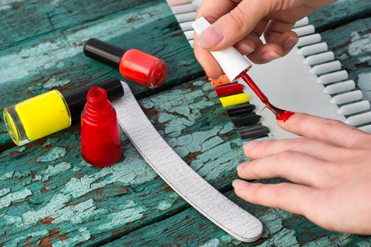 Tubes with varnish for nail polish of different colors on an old wooden background