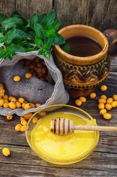 Clay mug with medicinal decoction of sea buckthorn and honey