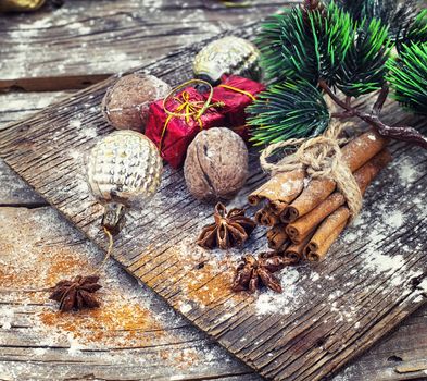 Old-fashioned Christmas decorations,cinnamon sticks,star anise and nuts on wooden retro background