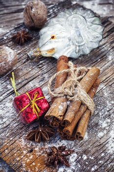 Old-fashioned Christmas decorations,cinnamon sticks,star anise and nuts on wooden retro background
