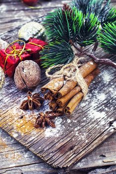 Old-fashioned Christmas decorations,cinnamon sticks,star anise and nuts on wooden retro background