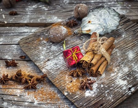 Old-fashioned Christmas decorations,cinnamon sticks,star anise and nuts on wooden retro background