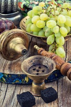 Hookah with fruit flavour on wooden table in vintage style
