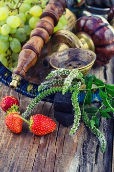 Hookah with fruit flavour on wooden table in vintage style