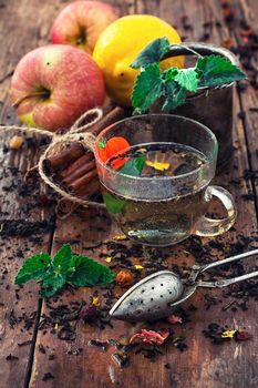 Cup with herbal tea on background apples and cinnamon