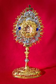 The golden relicquary of catholic church on red background
