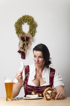 bavarian woman in a dirndl with sausages