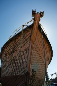 View of bow of an old wooden boat in dry dock.