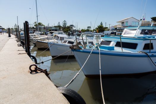 Small wooden fishing boats moured in a marina on a clear day.