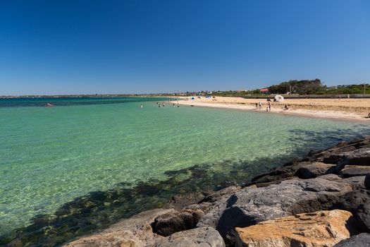 Beaches and clear water with rocks in the foreground in Melbourne, Australia.