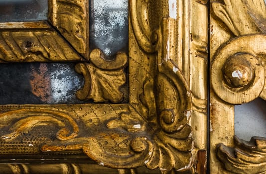 Detail of gilded wooden frame of an antique mirror.